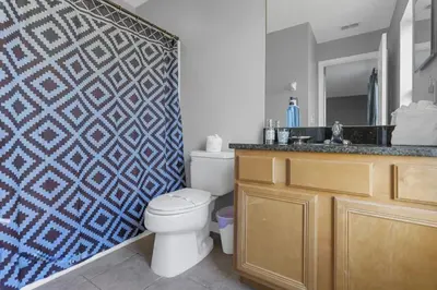 a bathroom with a toilet and a sink at 8503 Themed 7BD Villa- Game room Poolspa in Kissimmee