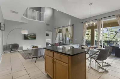 a kitchen and living room with a table and chairs at 8503 Themed 7BD Villa- Game room Poolspa in Kissimmee