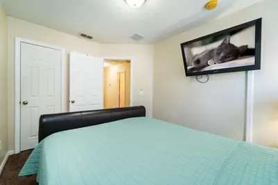 a bedroom with a bed with a tv on the wall at 1192SBC South Beach Villa in Kissimmee