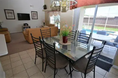 a dining room and living room with a glass table and chairs at Orlando Vacation Home Near Disney in Kissimmee