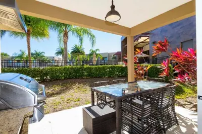 a patio with a glass table and a grill at Marvelous 4 Bd Close to Disney @ Magic Village 3153 in Orlando