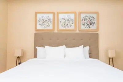 a bedroom with a white bed with three pictures on the wall at Marvelous 4 Bd Close to Disney @ Magic Village 3153 in Orlando