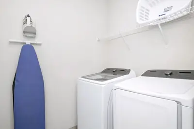 a white laundry room with a washer and dryer at Spectacular Home Near Disney With Private Pool And Waterpark & Resort Access At Encore Resorts Reunion - 465Sf in Kissimmee