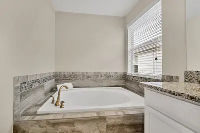 a white bath tub in a bathroom with a window at Gorgeous, Modern Home wPrivate Pool in Kissimmee