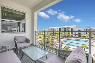 a balcony with a table and chairs and a view of a pool at NEW Magically Themed Condo w Pool View in Kissimmee