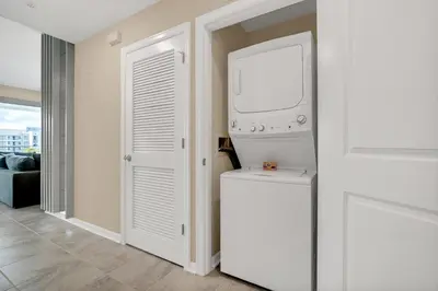 a laundry room with a washer and dryer next to a door at NEW Magically Themed Condo w Pool View in Kissimmee
