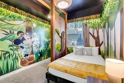 a bedroom with a mickey mouse mural on the wall at NEW Magically Themed Condo w Pool View in Kissimmee