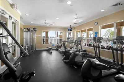 a gym with several treadmills and cardio machines at 3 BR 2 Miles to Disney, pool, free WiFi and more townhouse in Orlando