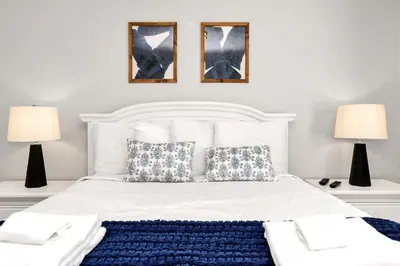 a bedroom with a white bed with two lamps at In the heart of Kissimmee Storey Lake Resort 4BD 3BA Pool Townhome 4SL4857 in Kissimmee