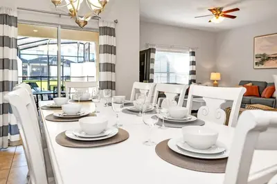 a dining room with a white table and chairs at In the heart of Kissimmee Storey Lake Resort 4BD 3BA Pool Townhome 4SL4857 in Kissimmee