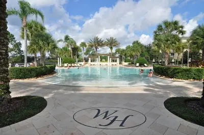 a pool at a resort with people in it at Spacious 4BR Home Themed Rooms, Pool, Near Disney in Orlando