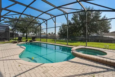 a swimming pool in a pavilion with two chairs at Luxury 5BR Villa Near Disney, Private Pool & Game Room in Orlando