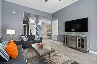 a living room with a couch and a flat screen tv at Luxury 5BR Villa Near Disney, Private Pool & Game Room in Orlando