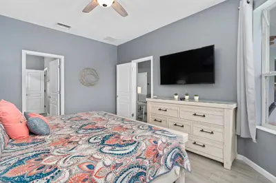 a bedroom with a bed and a flat screen tv at Luxury 5BR Villa Near Disney, Private Pool & Game Room in Orlando
