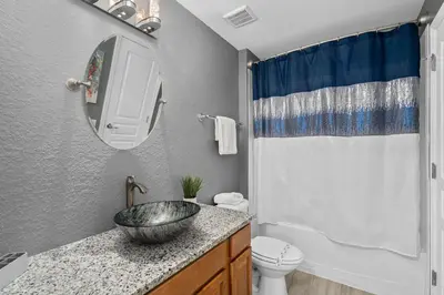 a bathroom with a sink and a toilet at Luxury 5BR Villa Near Disney, Private Pool & Game Room in Orlando