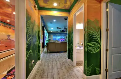a hallway with green walls and a bathroom at NEW! 14BR Disney-Area Resort with Bowling & Theater in Kissimmee