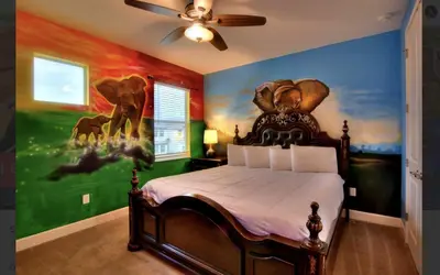 a bedroom with a bed with a painting on the wall at NEW! 14BR Disney-Area Resort with Bowling & Theater in Kissimmee