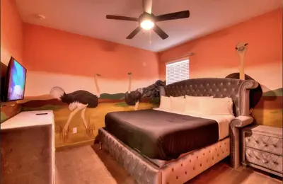 a bedroom with a bed and a room with a mural of birds at NEW! 14BR Disney-Area Resort with Bowling & Theater in Kissimmee