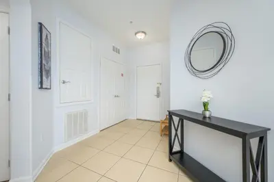 a hallway with a black table and a mirror at New Listing Beautiful Condo, Vista Cay - 3017 in Orlando