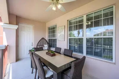 a dining room with a table and chairs and windows at Newly Renovated Premium Condo, Vista Cay - 2002 in Orlando