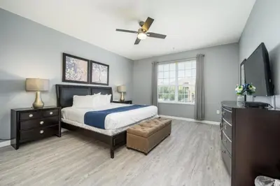 a bedroom with a bed and a flat screen tv at Newly Renovated Premium Condo, Vista Cay - 2002 in Orlando