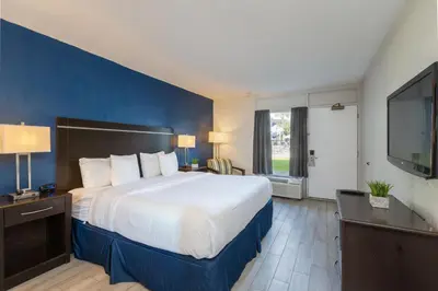 a hotel room with a large bed and a flat screen tv at Motel 6 Altamonte Springs FL in Orlando