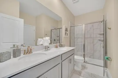a white bathroom with a sink and a shower at Storey Lake 9 BR Villa With Games Room and Theater home in Kissimmee