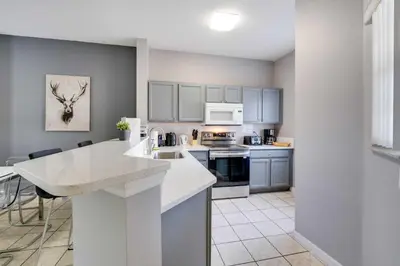 a kitchen with white cabinets and a white counter top at Kissimmee Escape about 10 Mi to Disney World! in Kissimmee