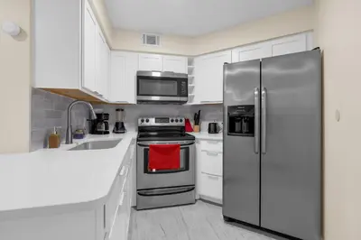 a kitchen with white cabinets and stainless steel appliances at Orlando Vacational Apartment 3919 in Orlando
