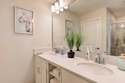 a bathroom with two sinks and a large mirror at 6 Mi to Disney Resort Hideaway with Pool Access! in Kissimmee
