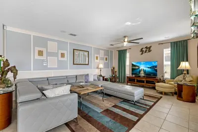 a living room with a couch and a tv at South Facing Pool with Spa and Lake View in Gated Resort of Bella Vida Nr Disney in Kissimmee