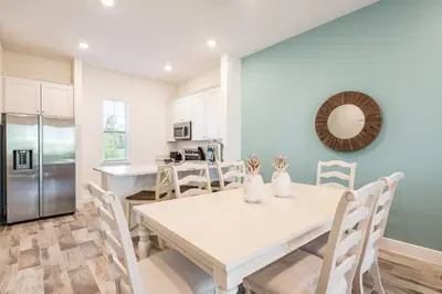 a kitchen and dining room with a white table and chairs at Blue Sky Cottage Near Disney With Private Pool & Margaritaville Resort And Island H20 Waterpark Access - 2912Sr in Orlando