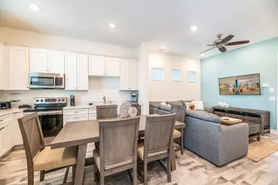 a kitchen and living room with a table and a couch at Charming Cottage Near Disney With Margaritaville Resort & Island H20 Waterpark Access - 2918Sr in Orlando