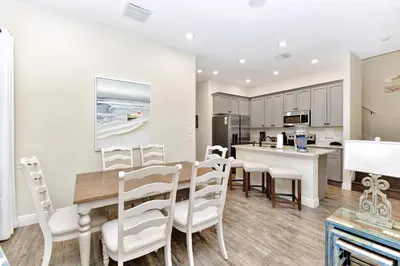 a dining room and kitchen with a table and chairs at Jamaican Spice Cottage Near Disney With Margaritaville Resort & Island H20 Waterpark Access - 2924Sr in Orlando