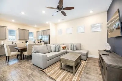 a living room with a couch and a table at Refreshing Blue Cottage Near Disney With Margaritaville Resort & Island H20 Waterpark Access - 2942Sr in Orlando