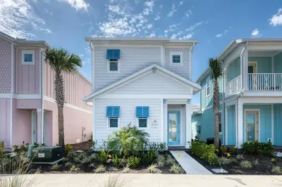 a white house with palm trees in front of houses at Refreshing Blue Cottage Near Disney With Margaritaville Resort & Island H20 Waterpark Access - 2942Sr in Orlando