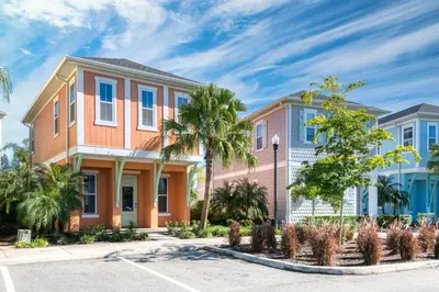 a house with palm trees in a parking lot at Charming Cottage With Private Hot Tub Near Disney With Margaritaville Resort & Island H2O Access - 3025Sp in Orlando