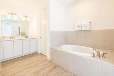 a white bathroom with a tub and a sink at Brilliant Cottage Near Disney With Private Pool & Margaritaville Resort & Island H20 Waterpark Access - 3080Ph in Orlando