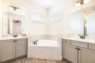 a bathroom with a tub and a sink and mirror at The Mermosa Cottage With Private Pool Near Disney With Margaritaville Resort & Island H2O Access - 8016St in Orlando