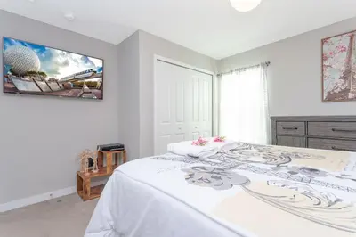 a white bedroom with a bed and a tv at Gorgeous and New House at Le Reve Resort (214221) in Kissimmee