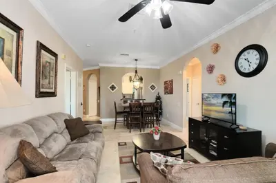 a living room with a couch and a clock on the wall at Spacious 3 bed, 2 bath Condo in Gated Community condo in Kissimmee