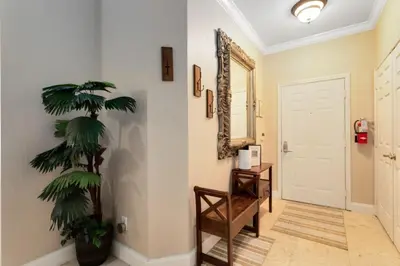 a hallway with a palm tree and a mirror at Spacious 3 bed, 2 bath Condo in Gated Community condo in Kissimmee