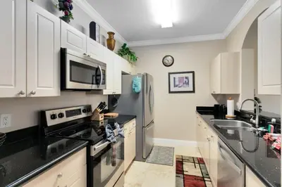 a kitchen with white cabinets and a stainless steel refrigerator at Spacious 3 bed, 2 bath Condo in Gated Community condo in Kissimmee
