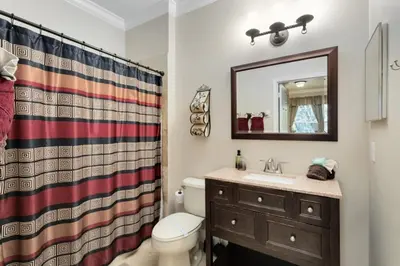 a bathroom with a toilet and a sink and a mirror at Spacious 3 bed, 2 bath Condo in Gated Community condo in Kissimmee