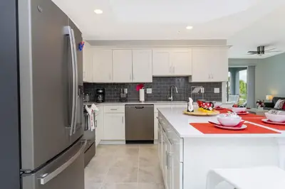 a kitchen with white cabinets and a stainless steel refrigerator at Gorgeous 3Bd 8 Guests @Storey Lake Resort Close to Disney 101 3191 in Kissimmee