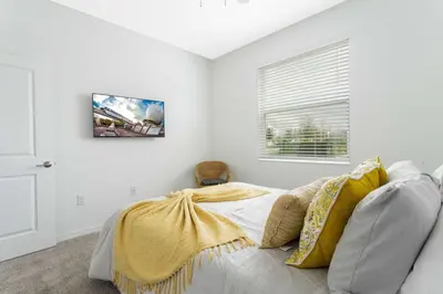 a bedroom with a bed with a yellow blanket on it at Gorgeous 3Bd 8 Guests @Storey Lake Resort Close to Disney 101 3191 in Kissimmee
