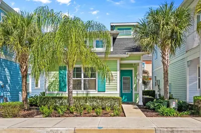 a house with palm trees in front of it at Beautiful Cottage Near Disney With Margaritaville Resort & Island H2O Access - 3029La in Orlando