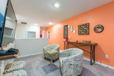 an orange room with two chairs and a table at Orlando Newest Resort Community Town Home townhouse in Orlando