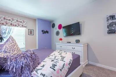 a bedroom with a bed with a tv on the wall at Orlando Newest Resort Community Town Home townhouse in Orlando