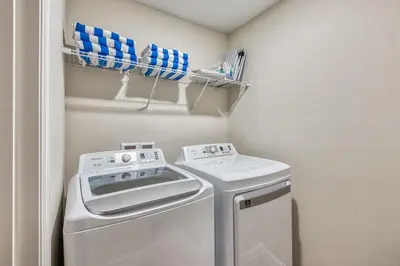 a small laundry room with a washer and dryer at Formosa Valley by UNE Homes in Orlando